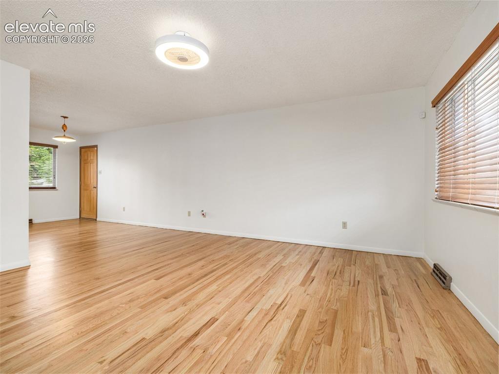 Image 3 of 34: Hardwood flooring, white walls, textured ceiling, ceiling-mounted light fix