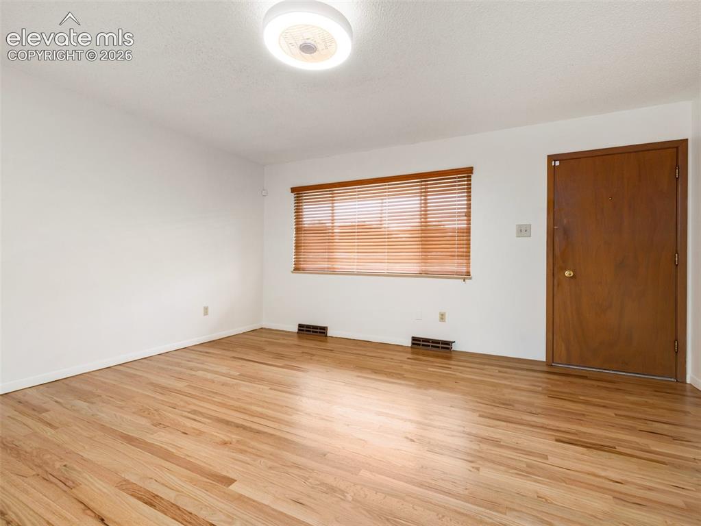 Image 5 of 34: Wood-finish flooring, white walls, wood window blinds, and recessed lightin