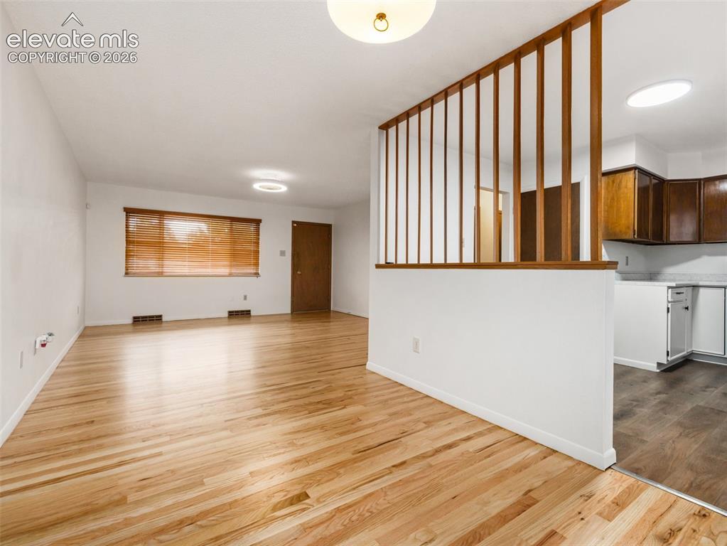 Image 7 of 34: Hardwood flooring, wood slat partition, white walls, overhead lighting, kit
