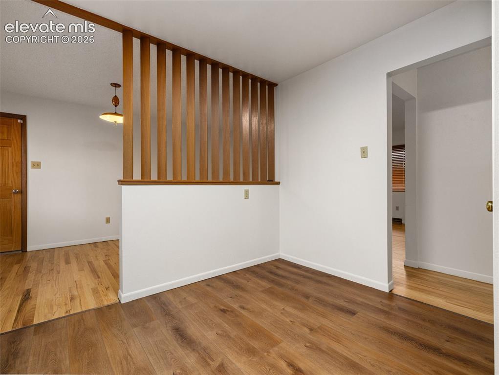 Image 9 of 34: Wood-finish flooring throughout, a decorative wood slat partition, and a li