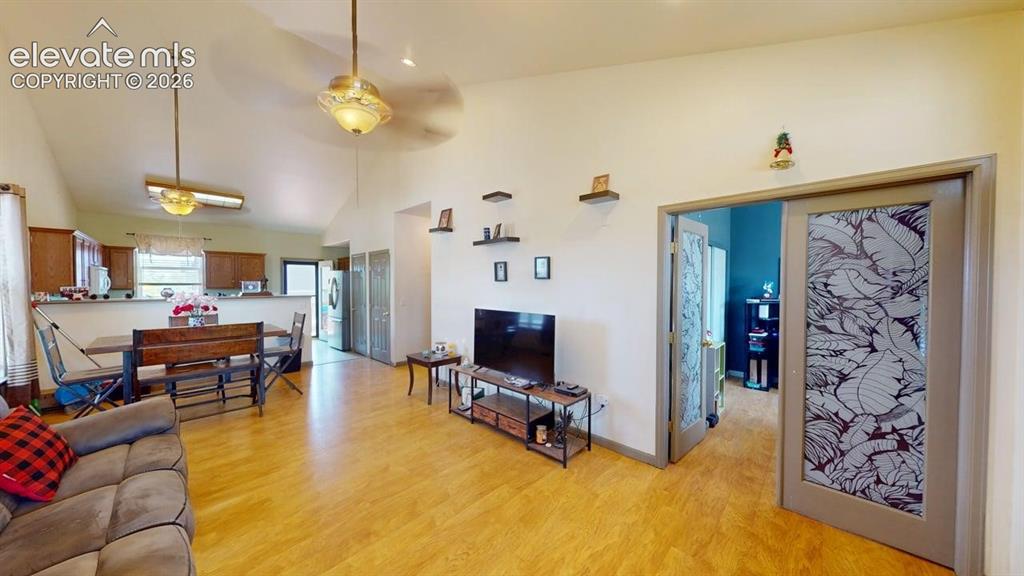 Image 10 of 20: Open-concept living area with vaulted ceilings and wood-finish flooring