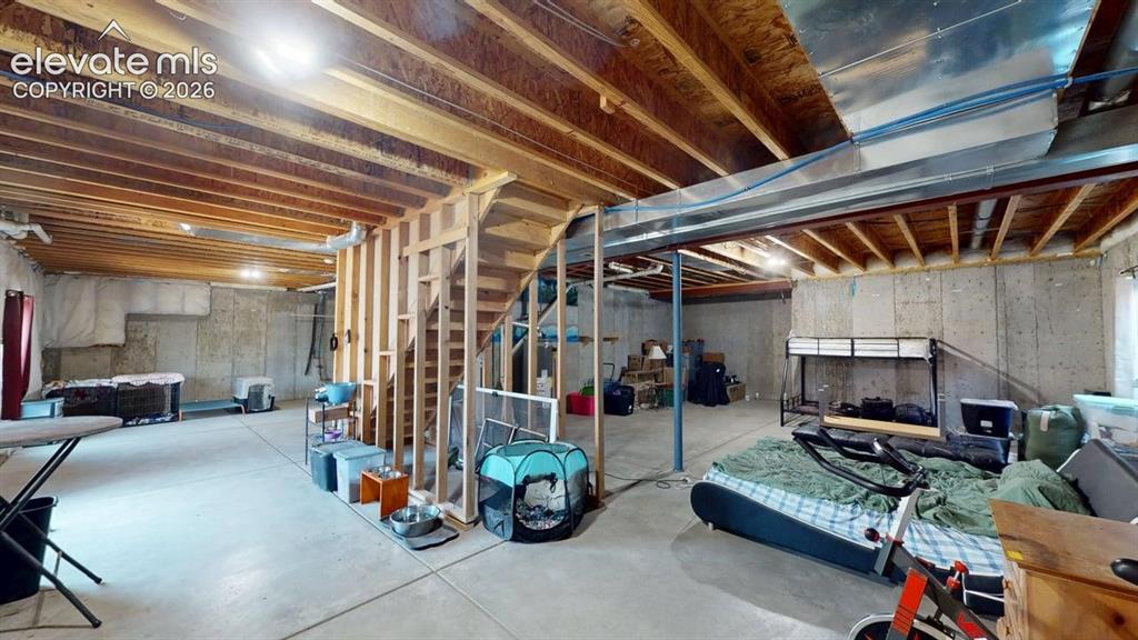 Image 18 of 20: Unfinished basement featuring exposed wood joists and concrete flooring