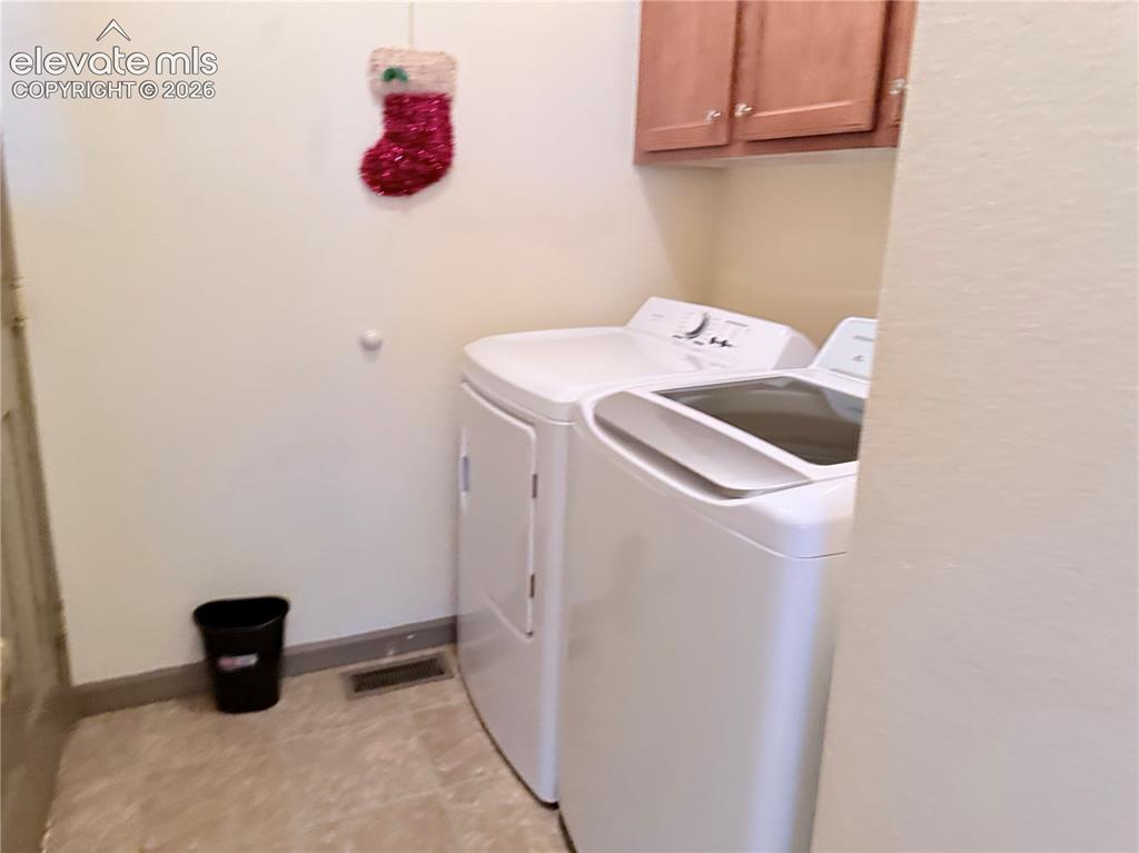 Image 20 of 20: Dedicated laundry area featuring a top-load washing machine and a front-loa