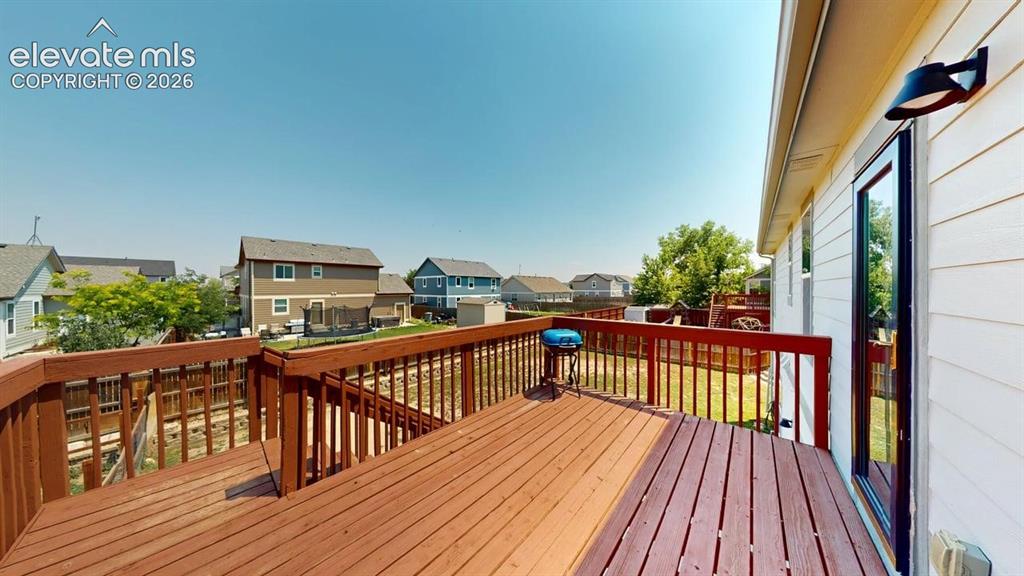 Image 3 of 20: Rear wood deck featuring a rich stain, horizontal railing, and direct acces
