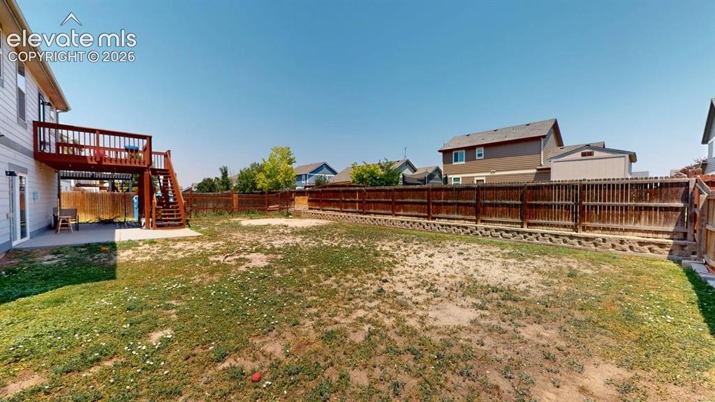 Image 4 of 20: Expansive backyard featuring a wood privacy fence, multi-level wood deck wi