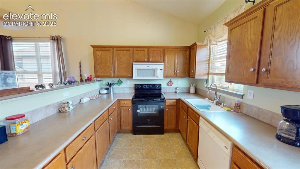 Image 6 of 20: U-shaped kitchen featuring light wood cabinetry, laminate countertops, an i
