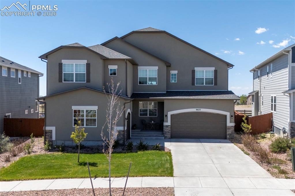 Caption: Contemporary stucco exterior with stone accents and a covered entry