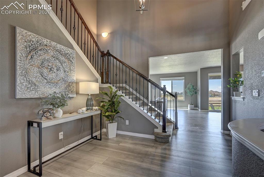 Image 10 of 50: Inviting entryway featuring wood-finish flooring, a contemporary staircase 
