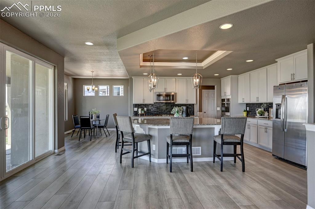 Image 11 of 50: Spacious kitchen featuring white cabinetry, stainless steel appliances, a c
