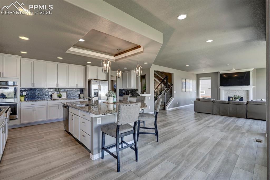 Image 13 of 50: Open-concept living area featuring a kitchen island with seating, pendant l