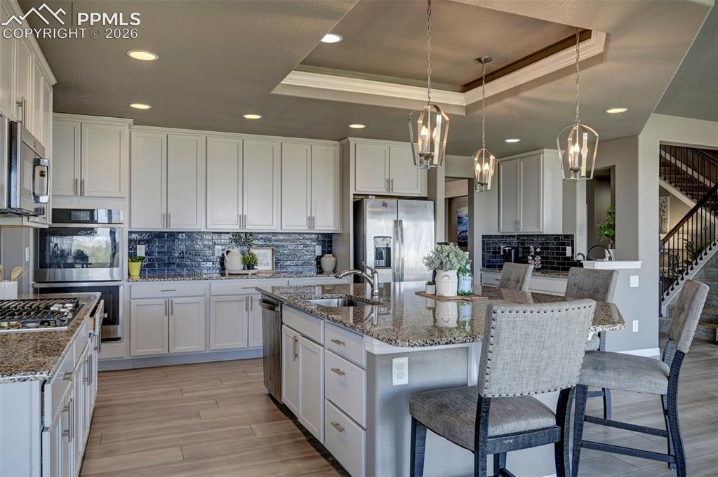 Image 14 of 50: Kitchen featuring an island with counter seating, stainless steel appliance