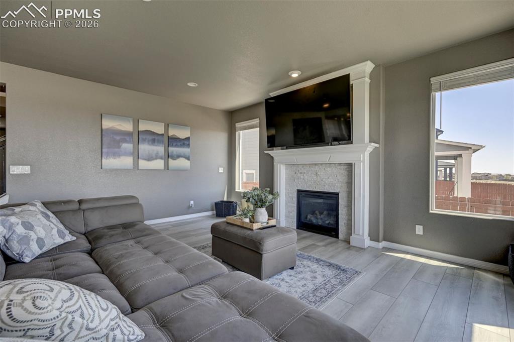 Image 22 of 50: Living area with light wood-finish flooring, a contemporary fireplace featu