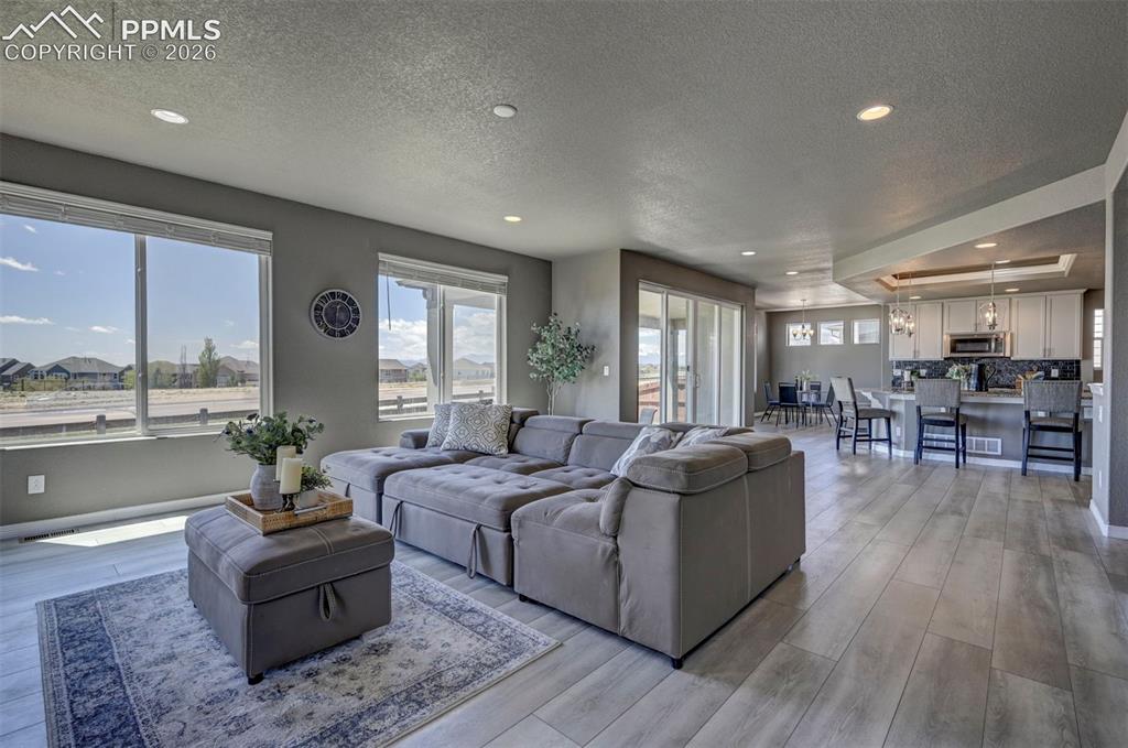 Image 24 of 50: Open-concept living space featuring wood-finish flooring, recessed lighting