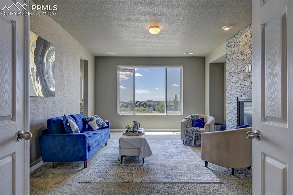 Image 28 of 50: Carpeted living space featuring a window with exterior visibility, a built-