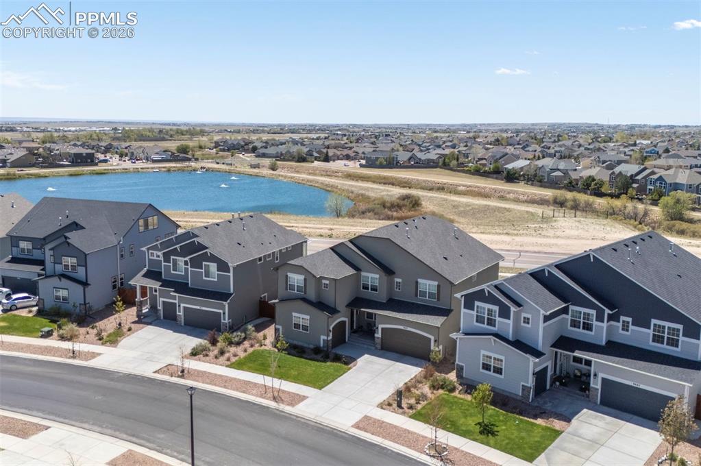 Image 3 of 50: Aerial perspective showcasing residential properties with a water feature