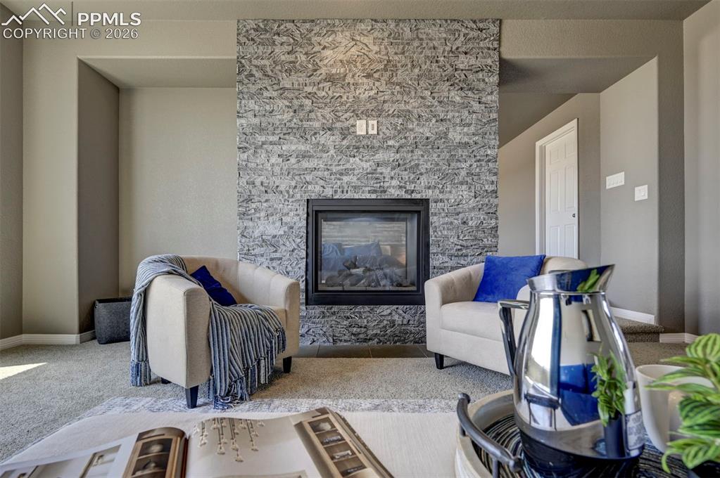Image 31 of 50: Stacked stone fireplace with a black metal insert