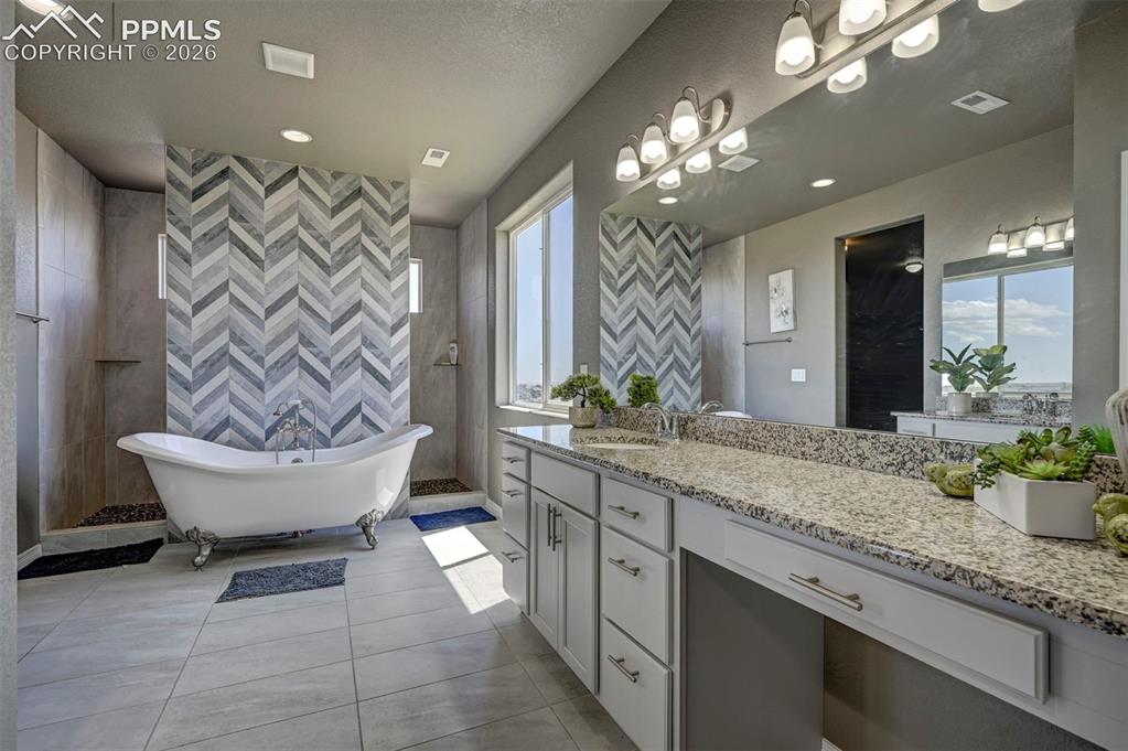 Image 34 of 50: Freestanding clawfoot tub with a chevron-patterned accent wall