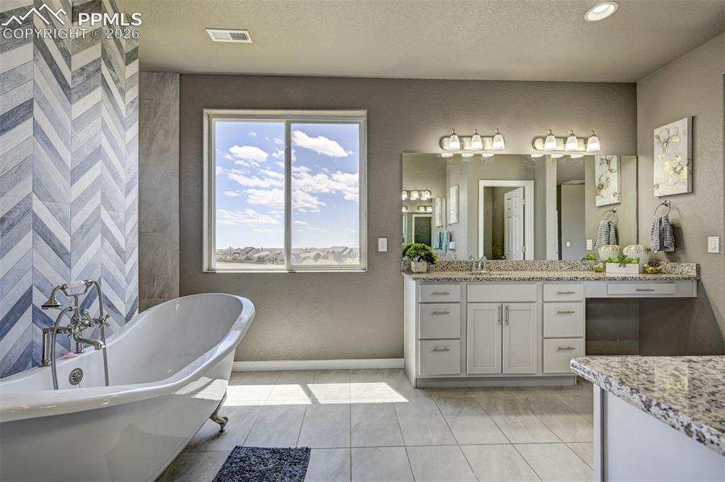 Image 36 of 50: Freestanding clawfoot tub with a chevron-patterned accent wall