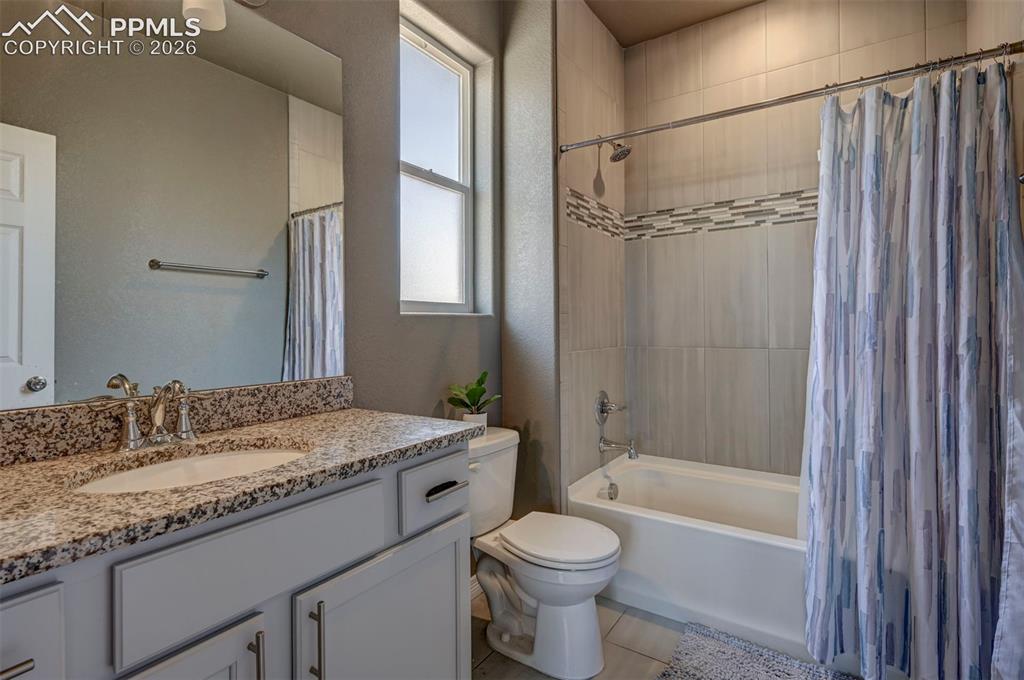Image 38 of 50: Bathroom featuring a single vanity with granite countertop, undermount sink