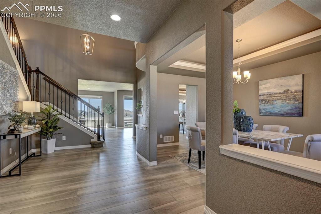 Image 4 of 50: Double-height foyer featuring wood-finish flooring and a staircase with wro