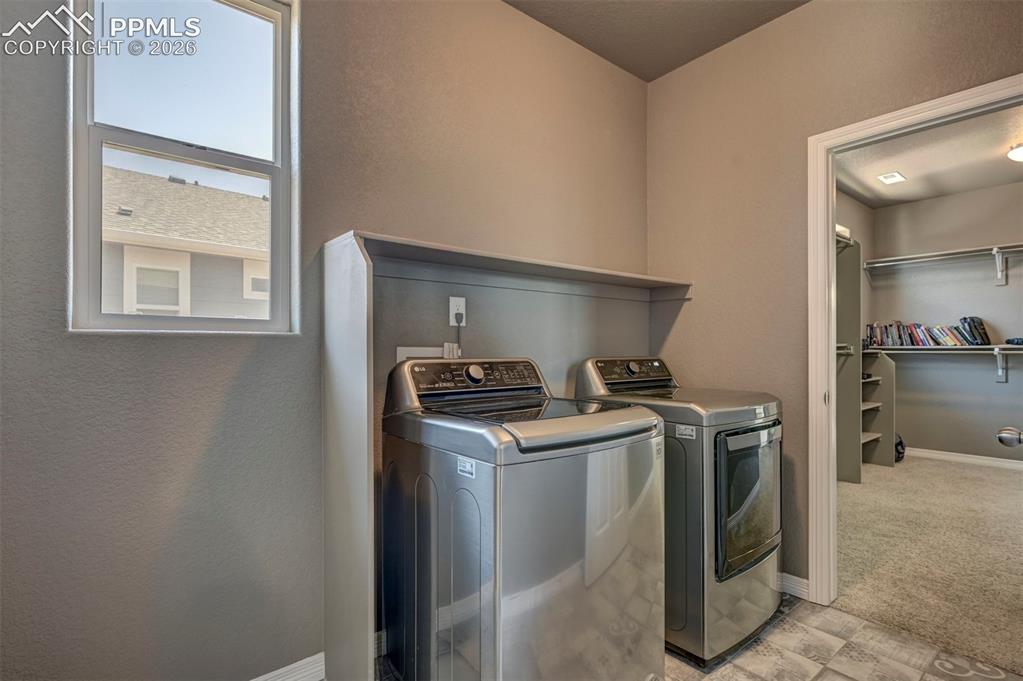Image 41 of 50: Laundry area featuring a window, built-in shelving, and tile flooring