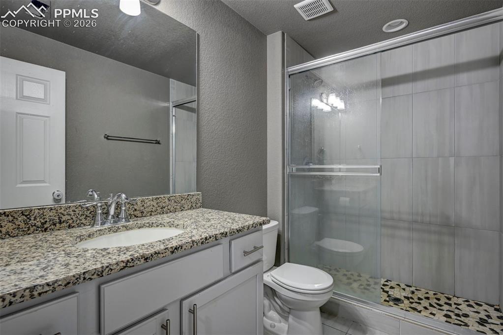 Image 45 of 50: Bathroom featuring a granite vanity countertop, undermount sink, chrome fau