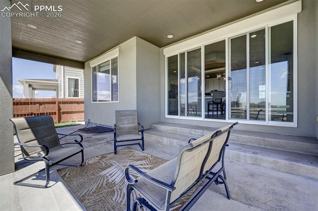 Image 47 of 50: Covered concrete patio featuring recessed lighting