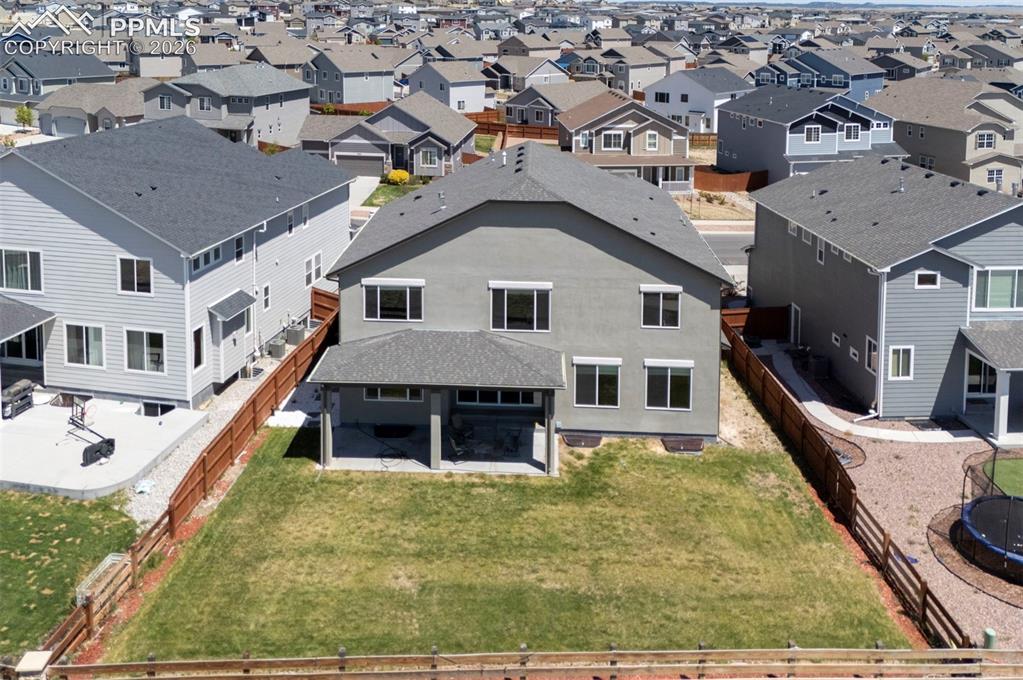 Image 50 of 50: Rear elevation featuring stucco siding, multiple windows, and a covered pat