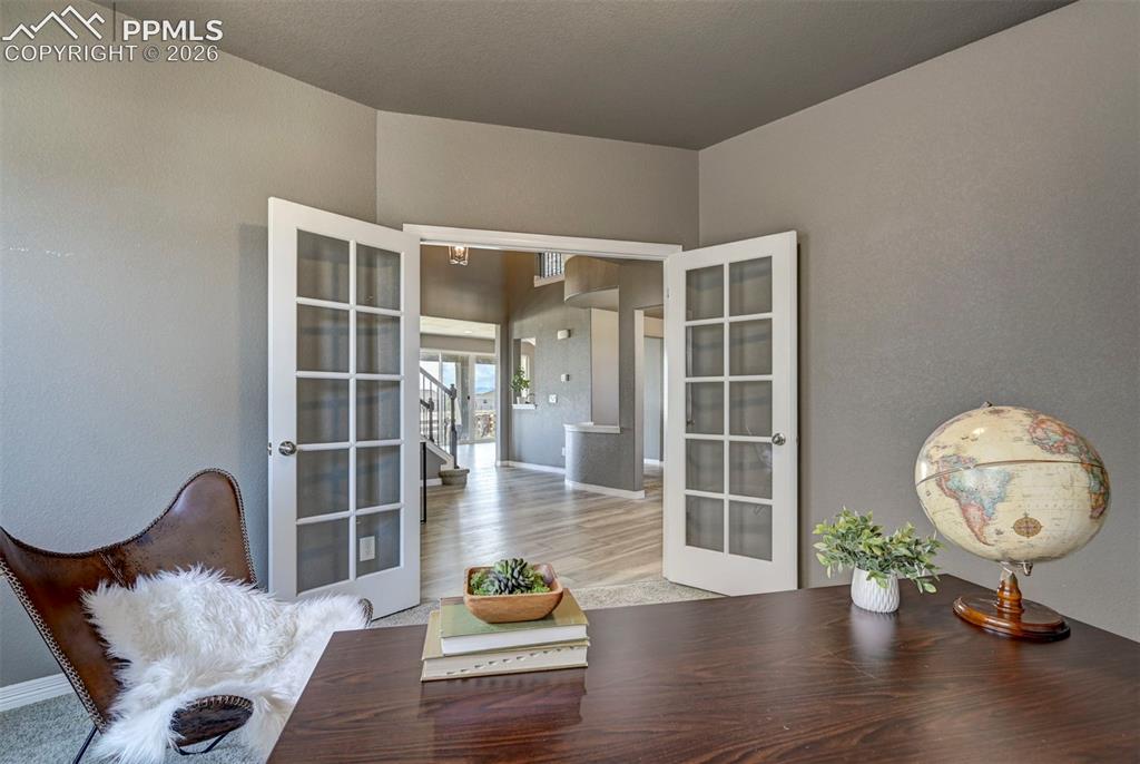 Image 7 of 50: French doors with glass panels opening to an interior with wood-finish floo