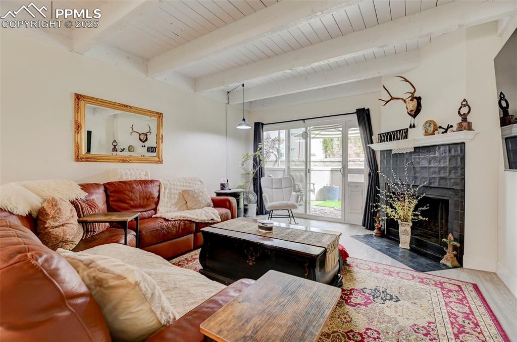 Image 5 of 16: Living room with wood finished floors, a wood ceiling with exposed beams, a