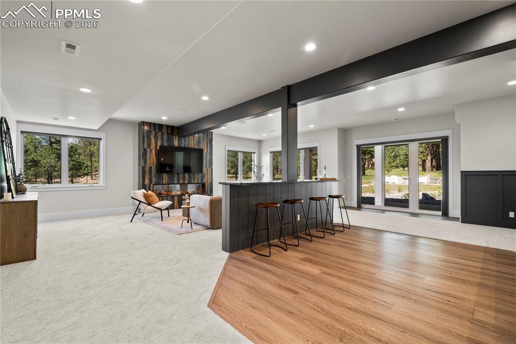 Image 27 of 48: Great room in basement overlooking the forest