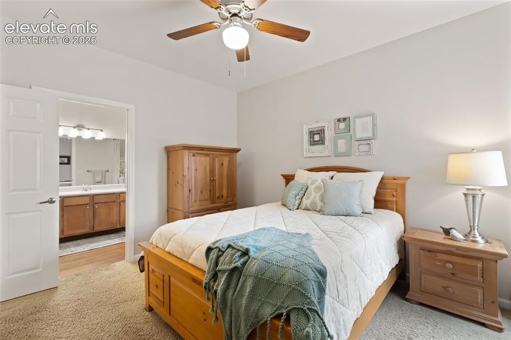 Image 12 of 31: Carpeted bedroom featuring a ceiling fan with integrated lighting, a white 