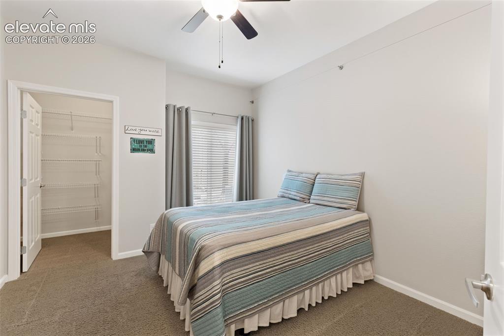 Image 17 of 31: Carpeted room featuring a ceiling fan with light fixture, window with blind