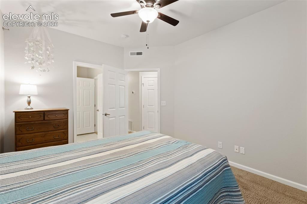 Image 18 of 31: Carpeted flooring, light neutral wall paint, white trim, and a ceiling fan 