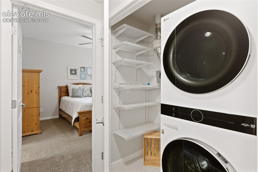 Image 21 of 31: Built-in closet shelving, integrated stacked washer and dryer, and overhead