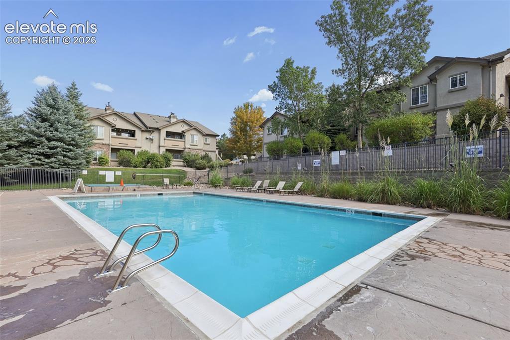 Image 22 of 31: Community swimming pool and hot tub/spa with concrete surround and metal ac