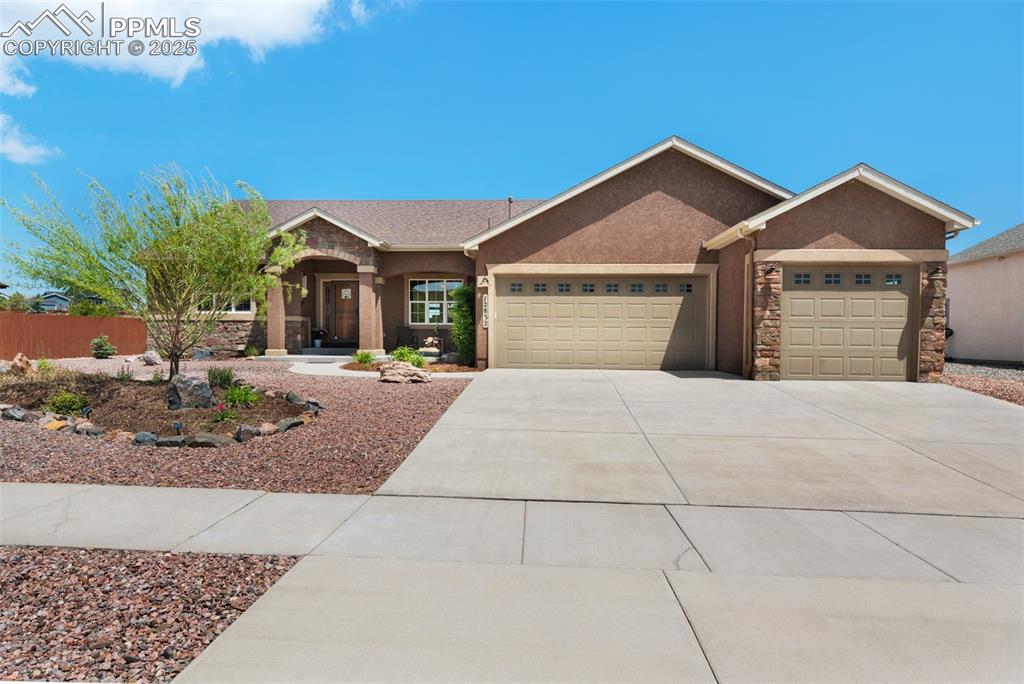 Caption: Ranch-style home featuring a stucco & stone exterior