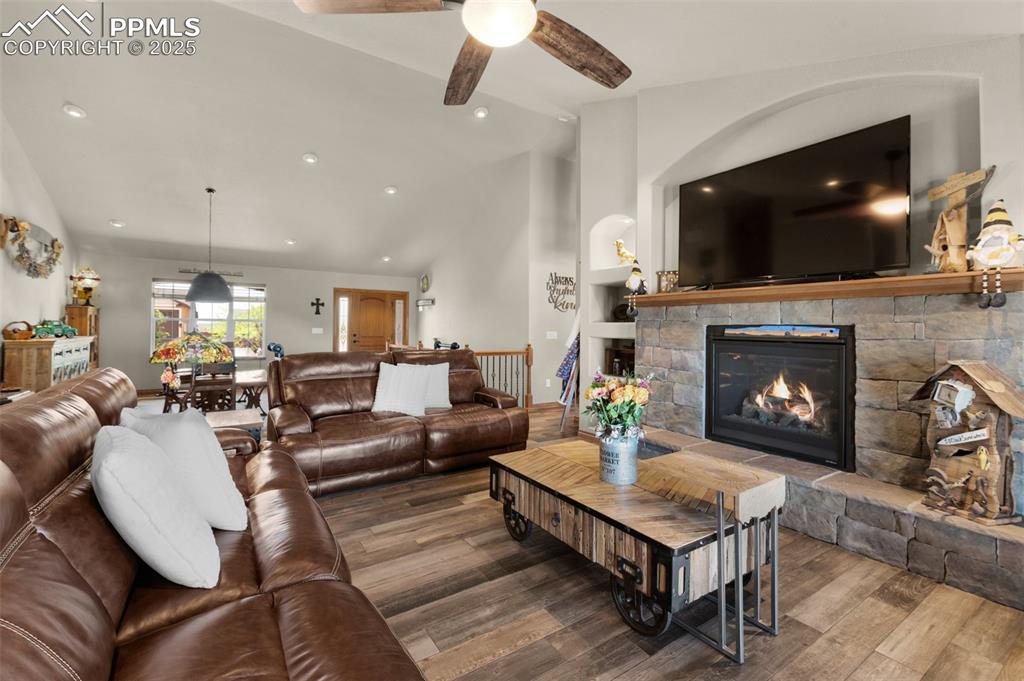 Image 10 of 48: Living room featuring lofted ceiling, wood finished floors, ceiling fan, a 