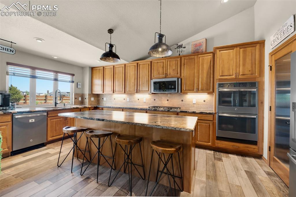 Image 11 of 48: Kitchen with stainless steel appliances, double ovens, granite countertops,