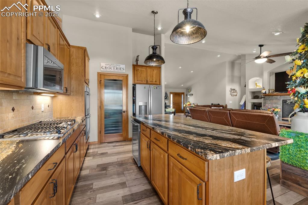 Image 13 of 48: Kitchen featuring appliances with stainless steel finishes, vaulted ceiling