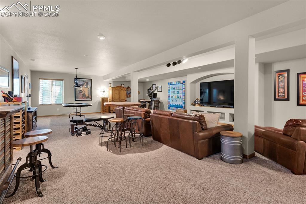Image 27 of 48: basement family room with wet bar