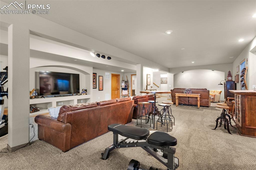 Image 28 of 48: Living area with light carpet and recessed lighting