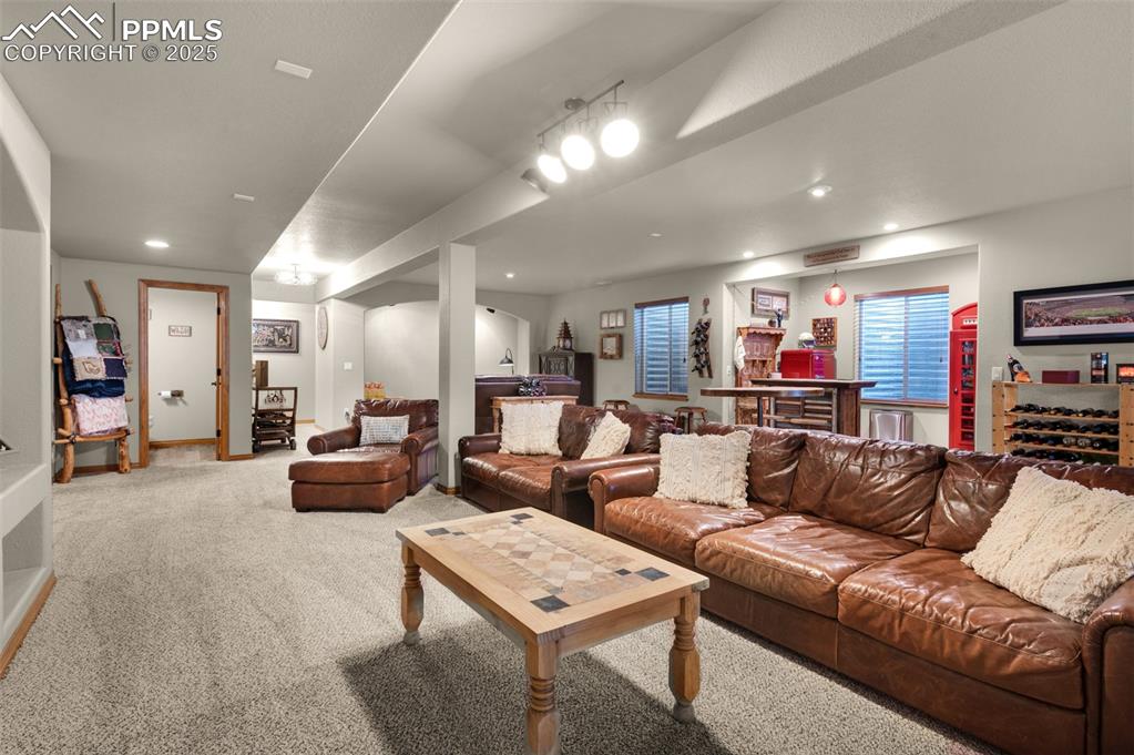 Image 29 of 48: Living area with carpet flooring, a dry bar, and recessed lighting