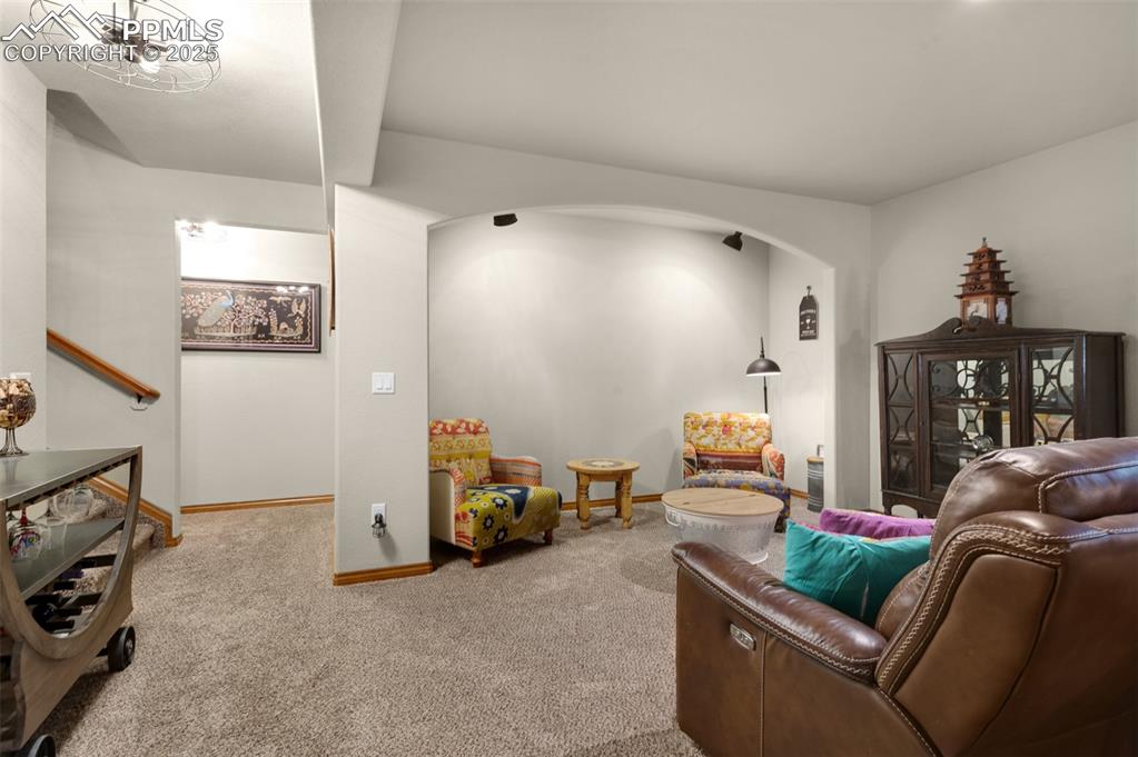 Image 31 of 48: Carpeted living area featuring arched walkways and baseboards