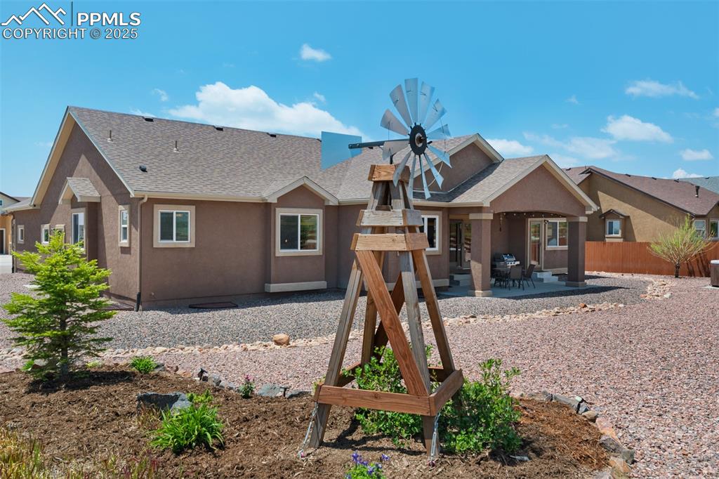 Image 42 of 48: Rear view of property featuring a patio area, stucco siding, and a shingled