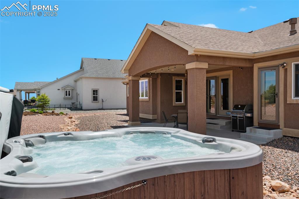 Image 43 of 48: View of patio featuring a hot tub and area for grilling