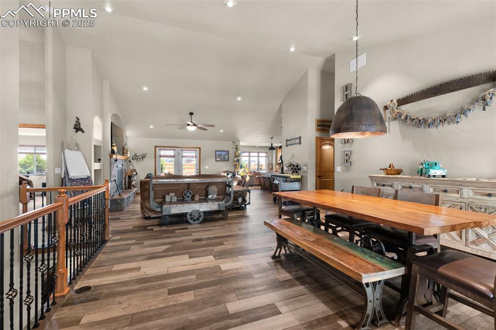 Image 5 of 48: Dining room featuring rustic lighting, high vaulted ceiling, and wood look 