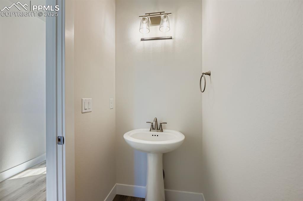 Image 10 of 27: Bathroom featuring wood finished floors and baseboards