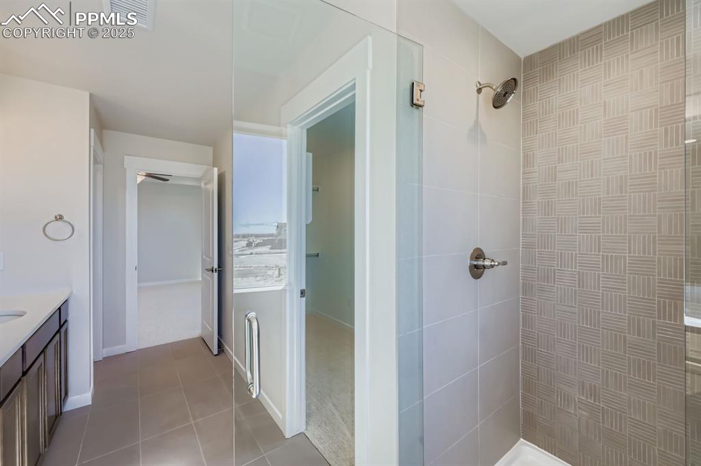 Image 14 of 27: Full bathroom with vanity, a stall shower, and light tile patterned floors