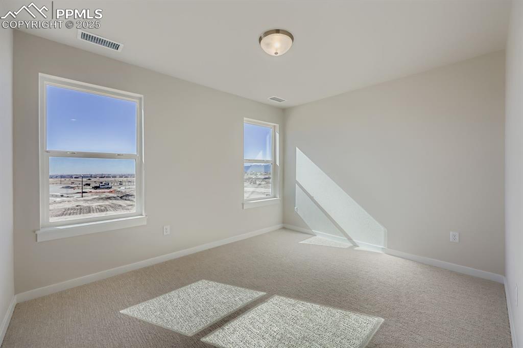 Image 15 of 27: Empty room with carpet floors and baseboards